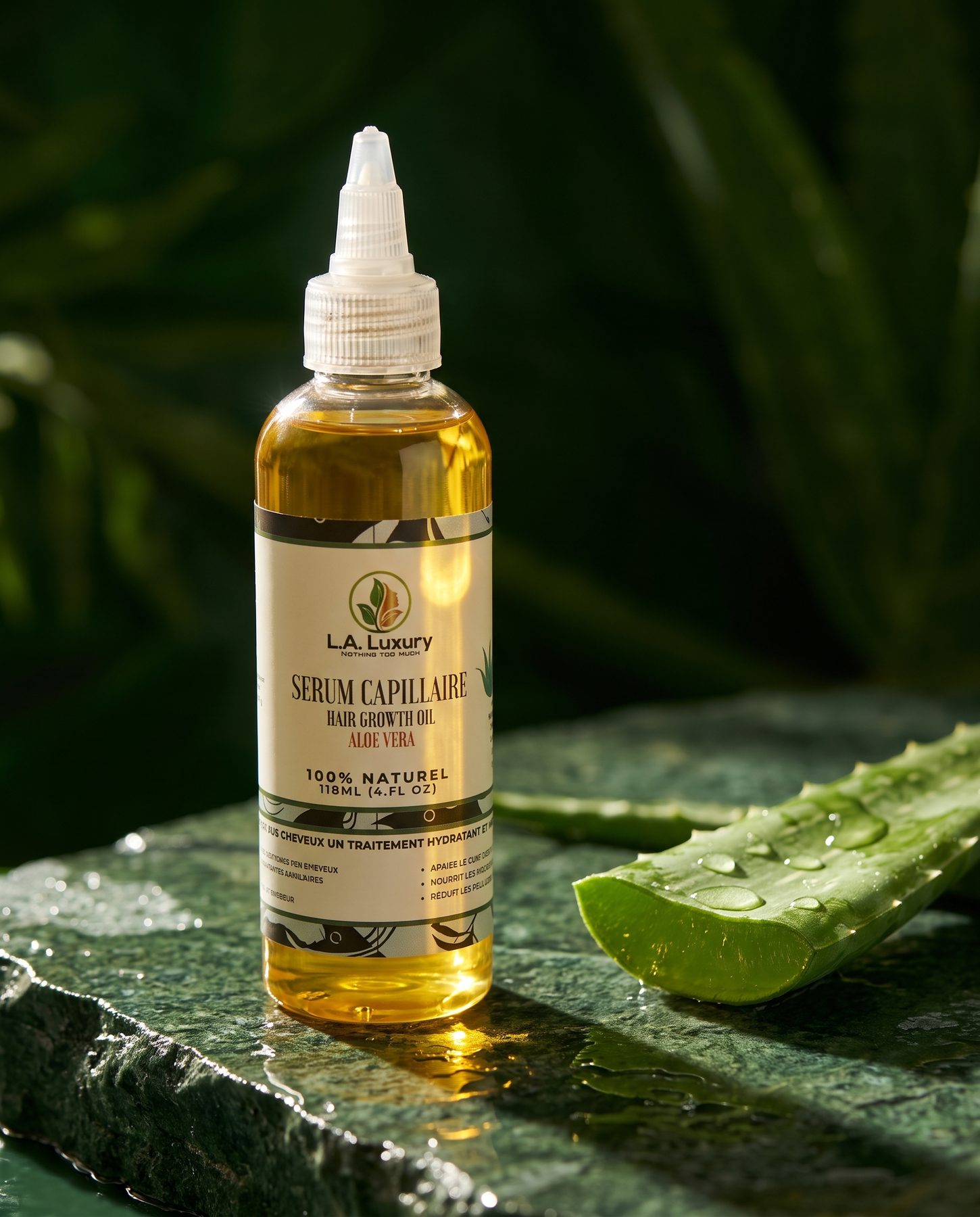 Sérum capillaire L.A. Luxury à l'aloe vera sur une pierre verte